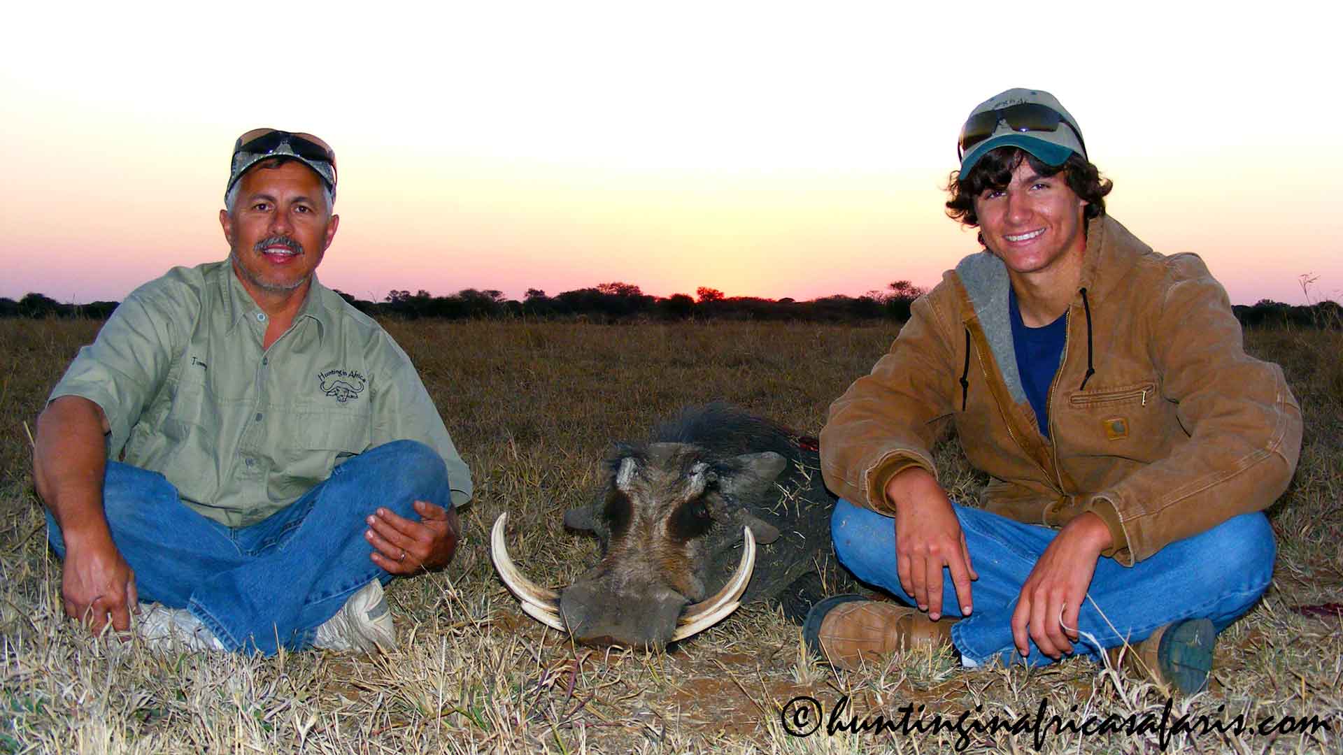 Father and son trophy warthog hunting South Africa A proud father and son with their massive trophy warthog $text{(Phacochoerus africanus)}$ tusker, successfully taken in the Limpopo Province, South Africa.