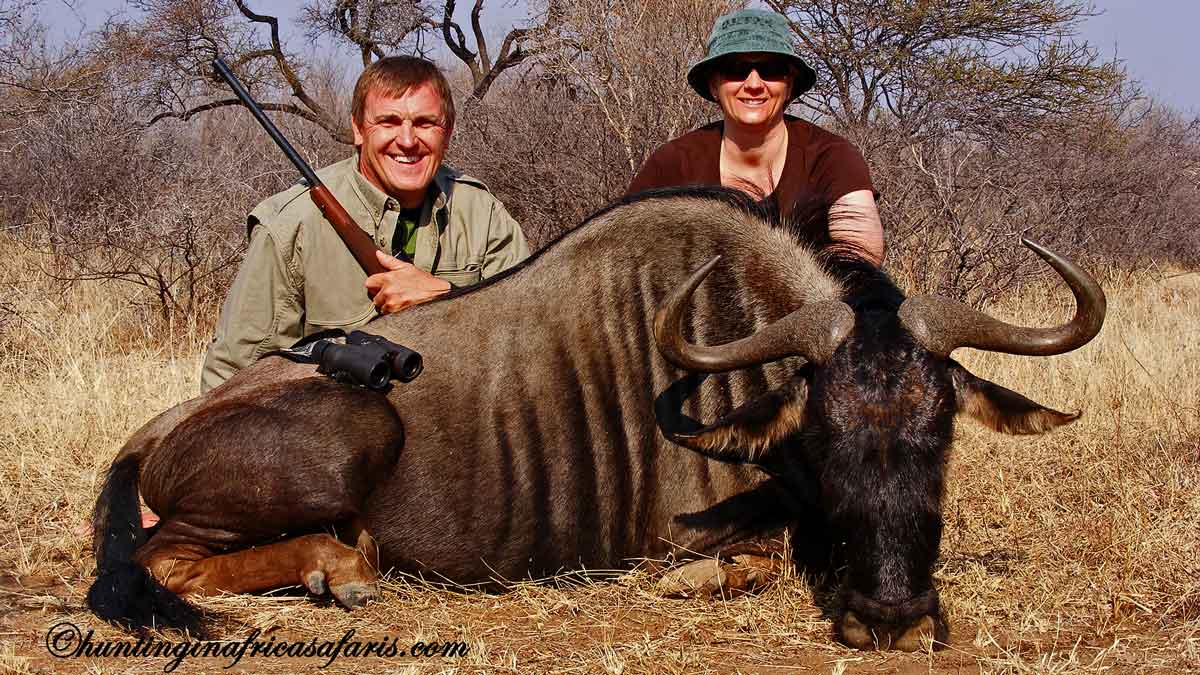 Proud hunter celebrating a successful blue wildebeest hunt on a premier South African concession